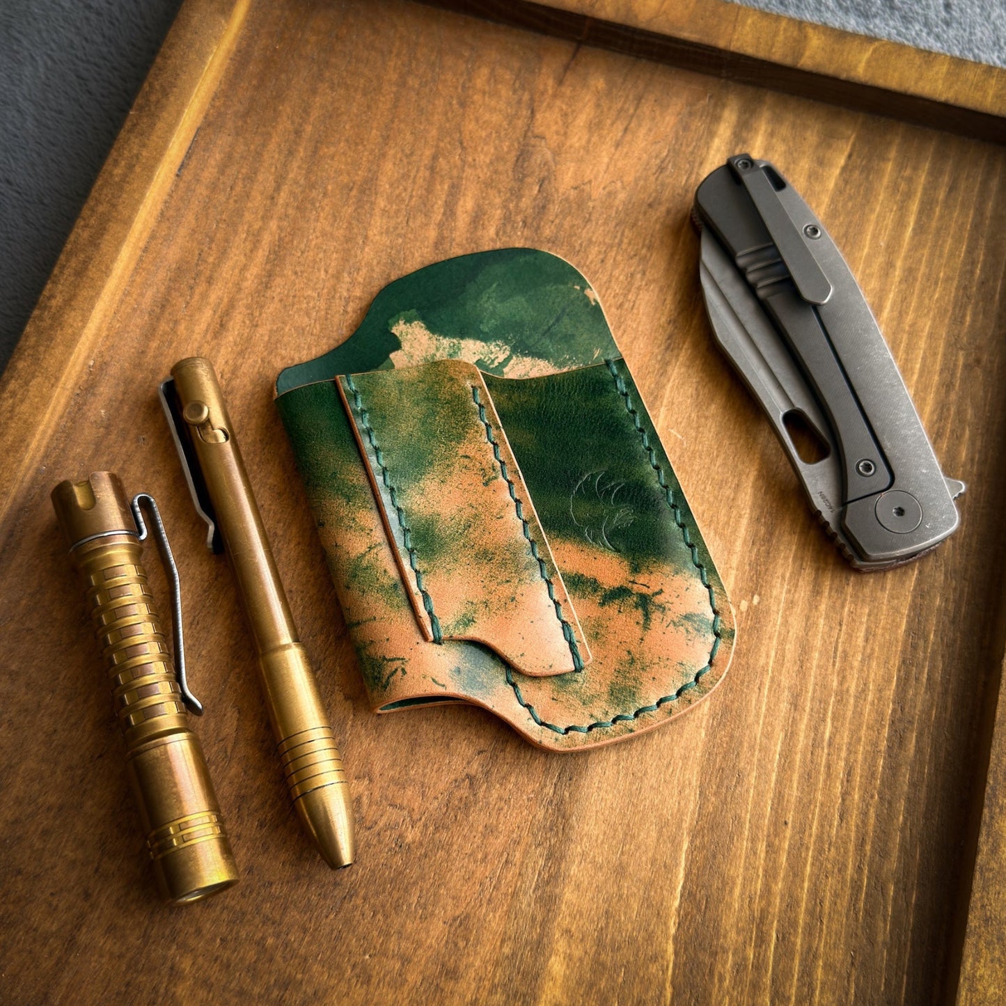 Handmade EDC pocket organizer crafted from genuine Green Marbled Rocado Shell Cordovan leather, featuring custom pockets for a folding knife, flashlight, and pen