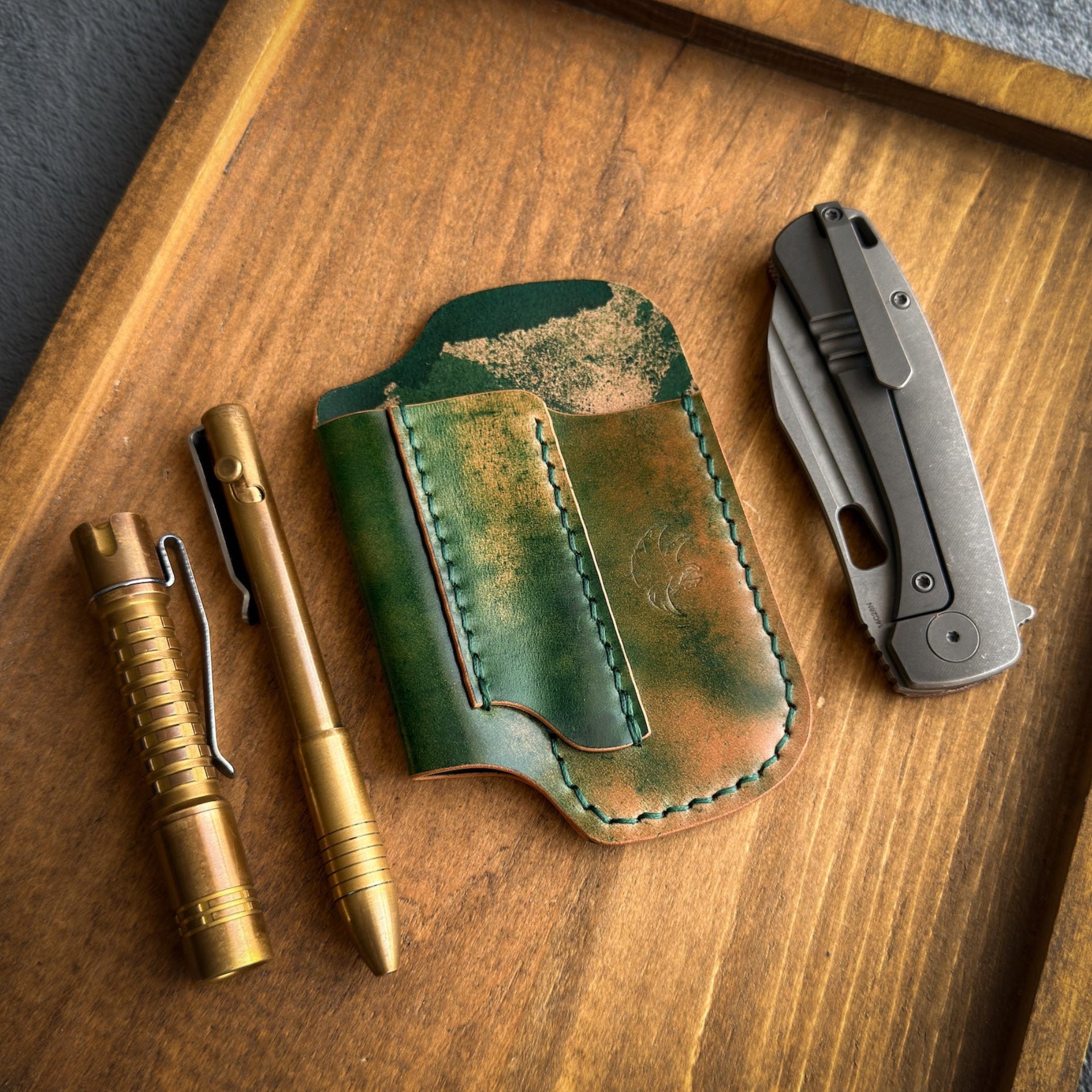 Handmade EDC pocket organizer crafted from genuine Green Marbled Rocado Shell Cordovan leather, featuring custom pockets for a folding knife, flashlight, and pen